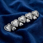 Silver Polished Hearts Hair Barrette on a blue fabric background