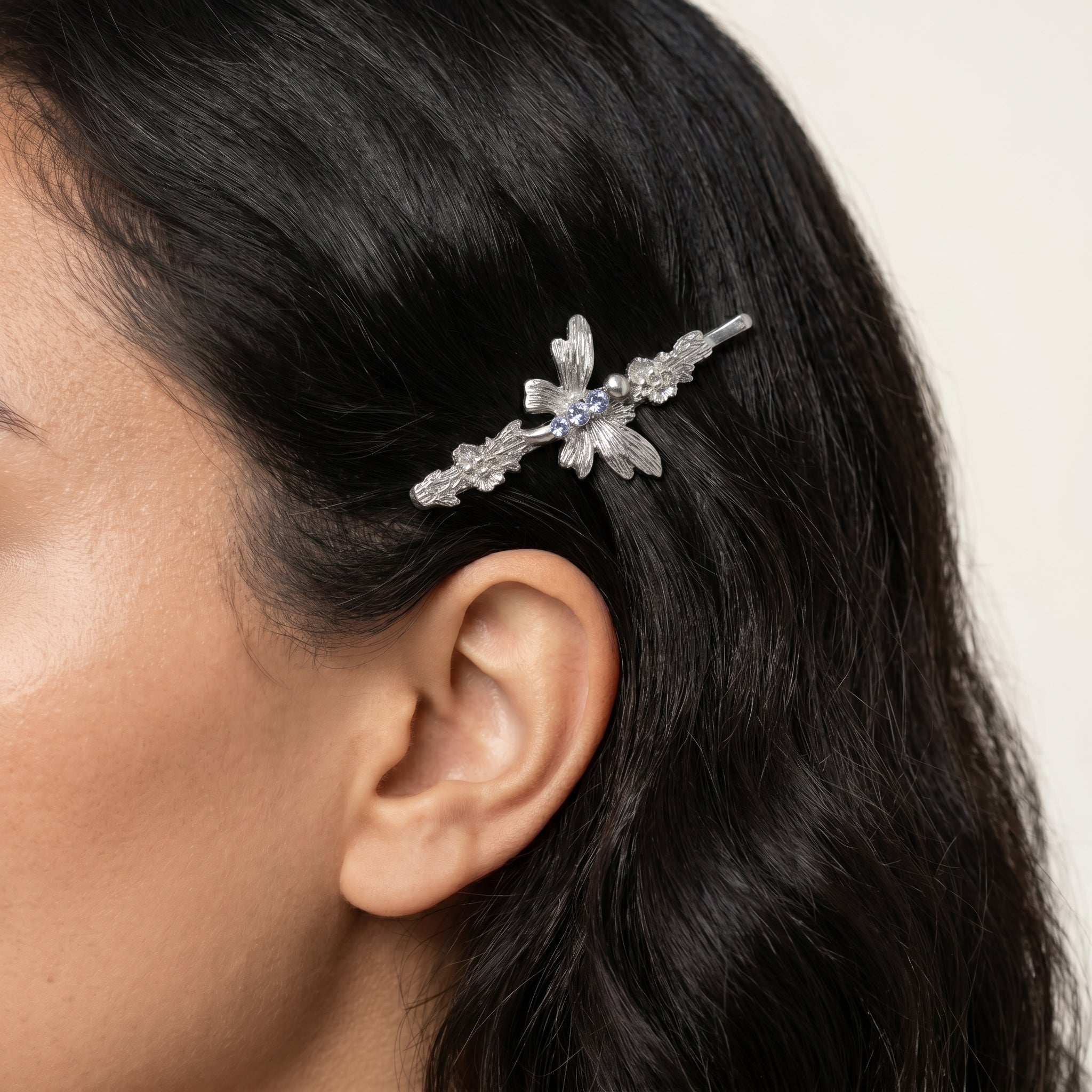 Light Sapphire Blue Crystal Butterfly Flower Bobby Pin worn by a woman with dark hair 