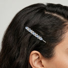 Woman wearing a blue crystal bobby pin hair clip with a floral design