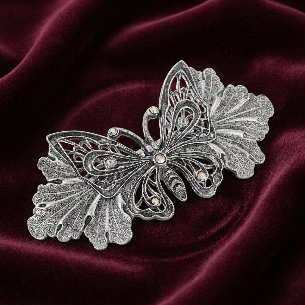 Silver butterfly barrette on a dark red satin background