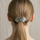 Butterfly hair clip in a person's hair against a neutral background