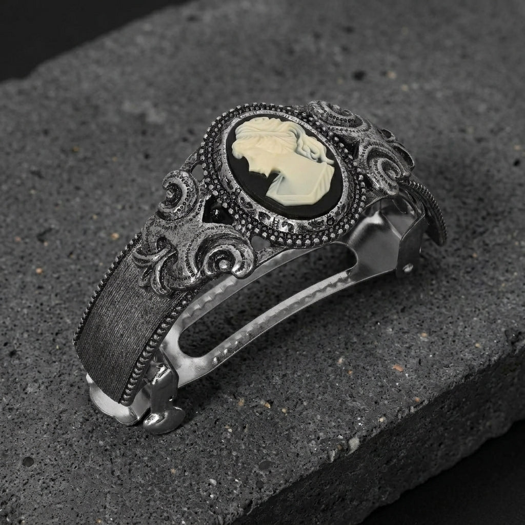 Decorative barrette with a cameo design on a dark stone surface