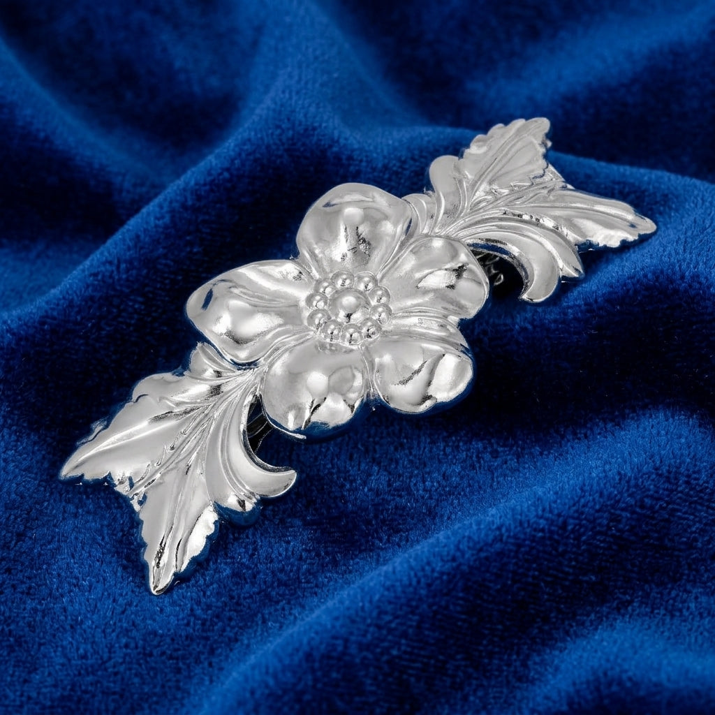 Silver floral barrette on a blue velvet background