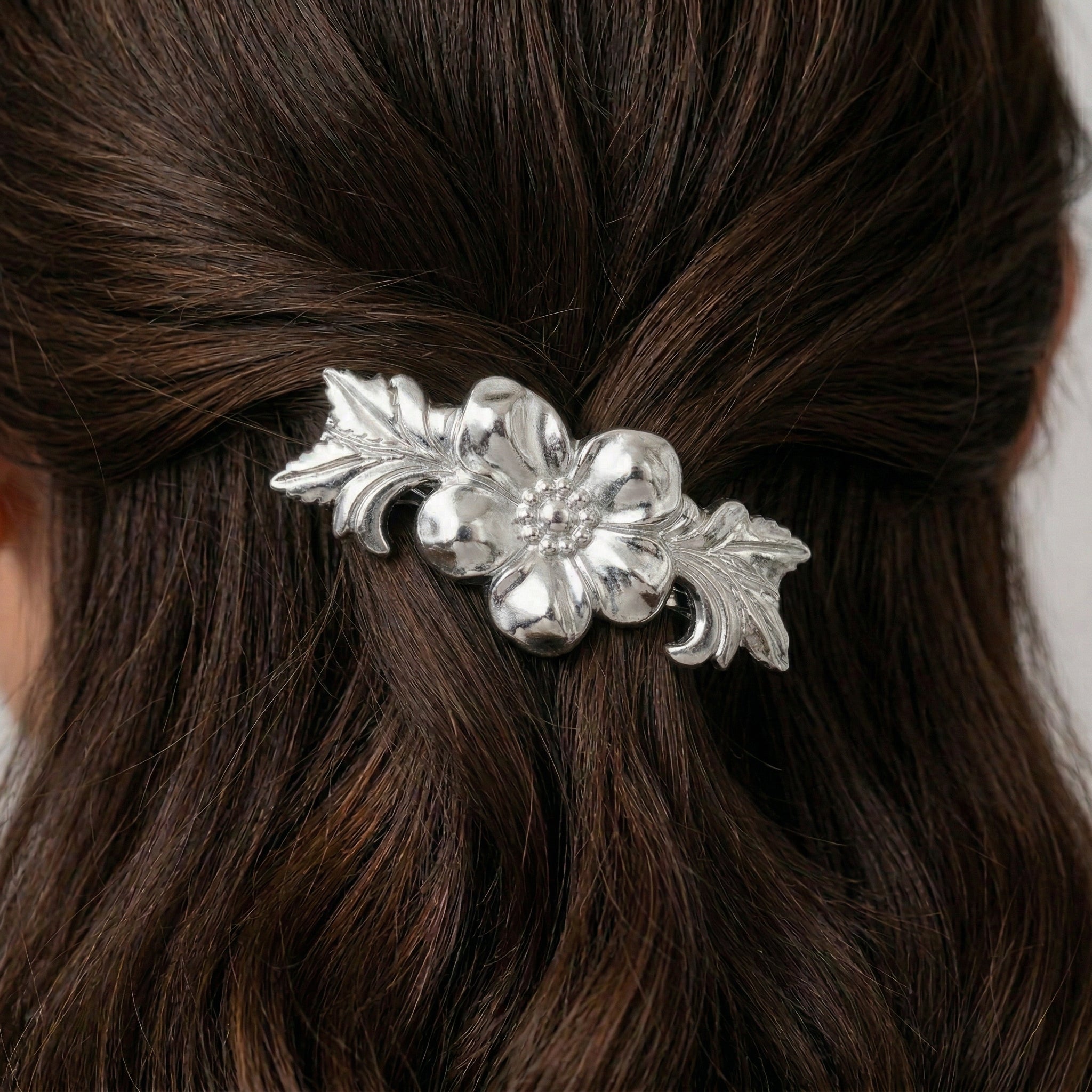 Silver flower barrette worn by a woman