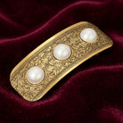 Golden Floral Etched Faux Pearls Hair Barrette on red fabric 