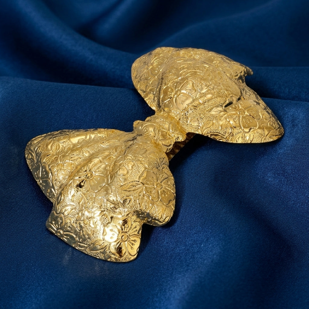 Golden bow barrette on dark blue fabric