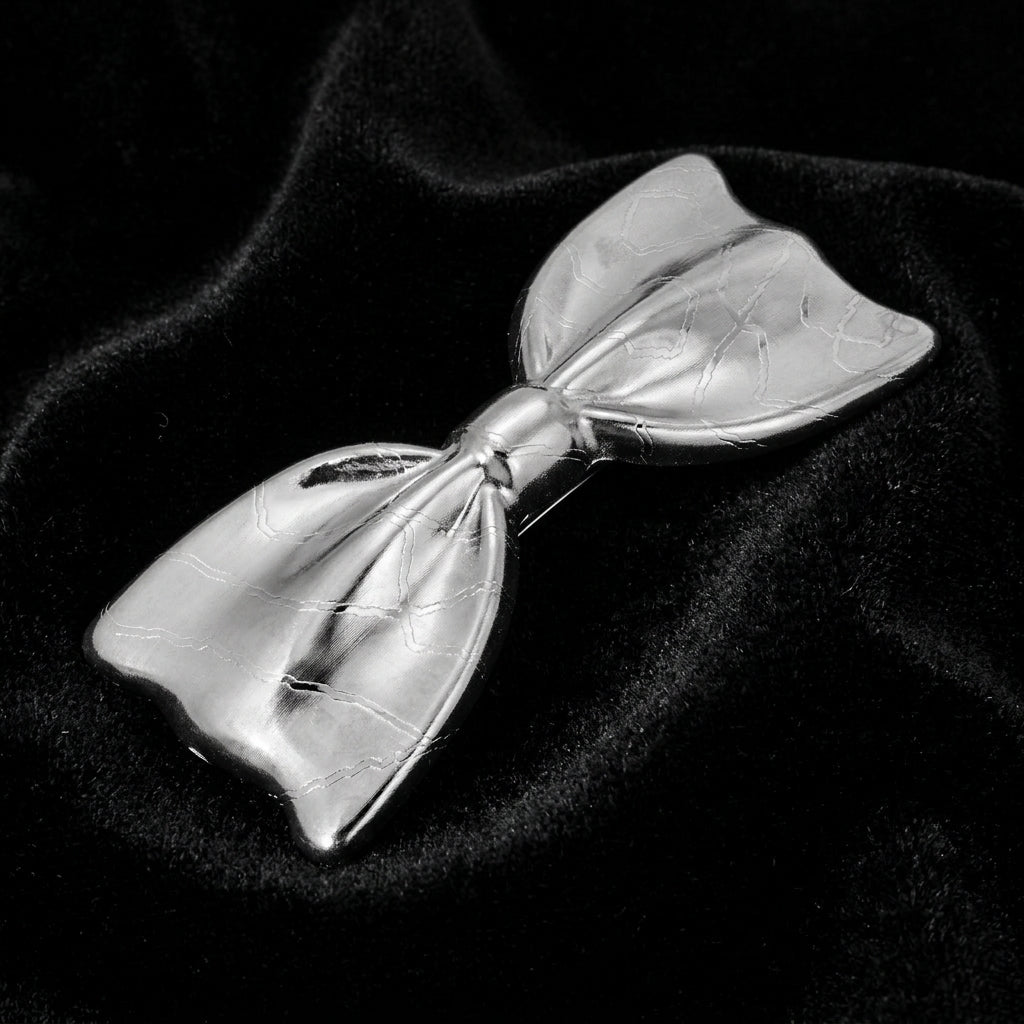 Silver bow-shaped barrette on a black background