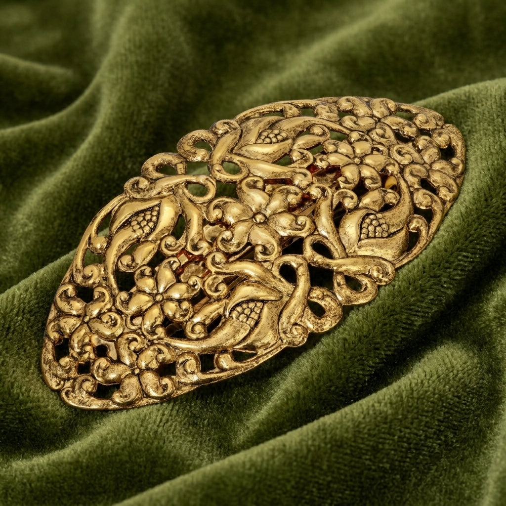 Decorative gold barrette on a green fabric background