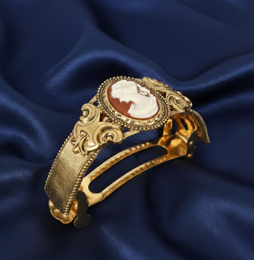 Gold barrette with a cameo design on a blue satin background.