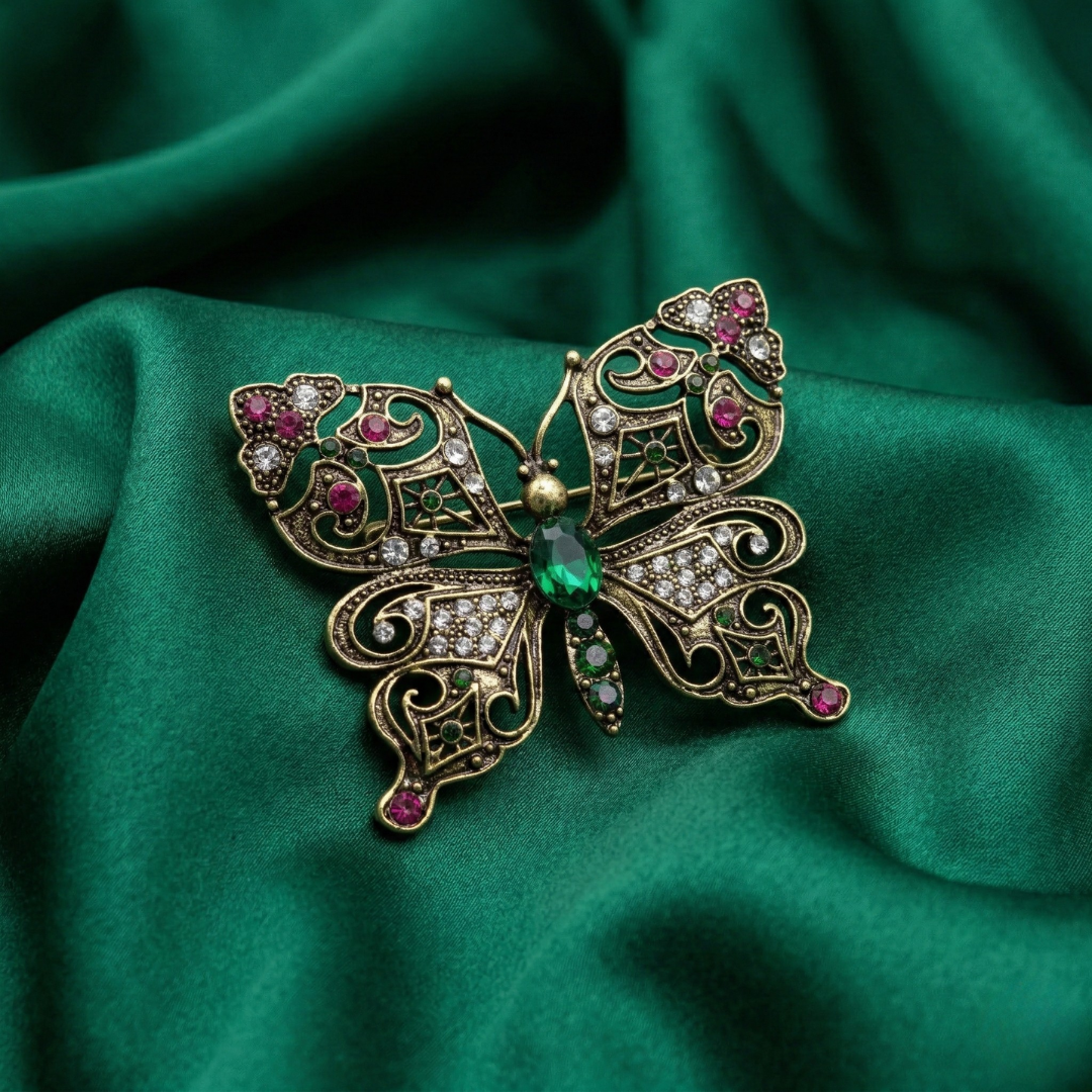 Decorative butterfly brooch with crystals on a green fabric background