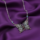 Butterfly pendant necklace on a purple fabric background
