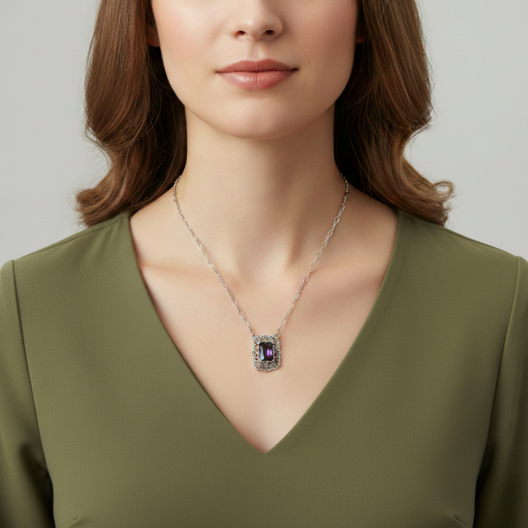 Woman wearing a necklace with a purple crystal against a neutral background