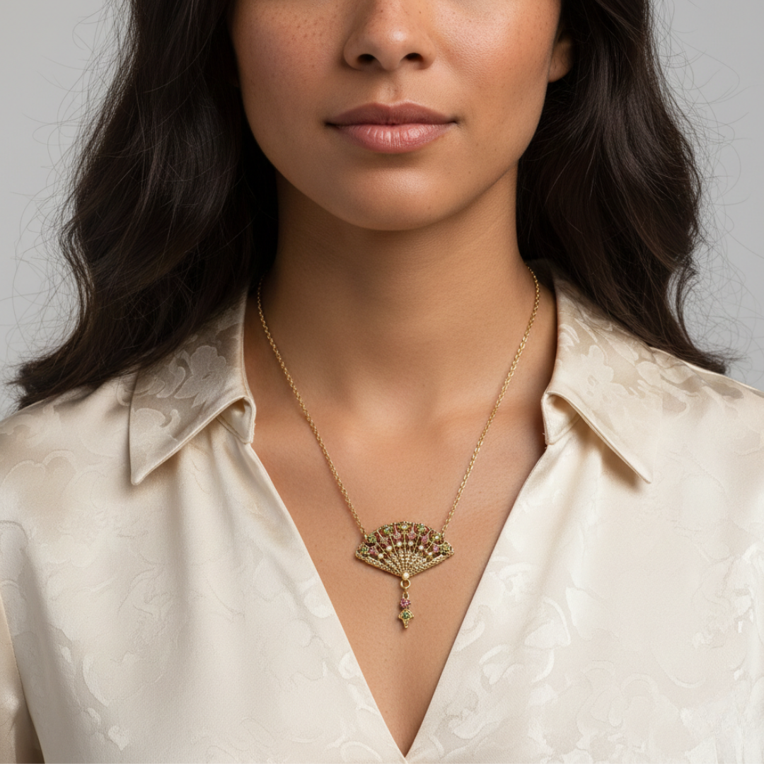 Woman wearing a gold necklace with a fan-shaped pendant on a neutral background
