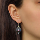 Up close look at a female model wearing our Gold Tone Iridescent AB Crystal & Blue Stone Teardrop Wire Earrings