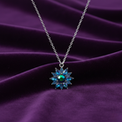 Necklace with a shiny, floral pendant on a purple fabric background
