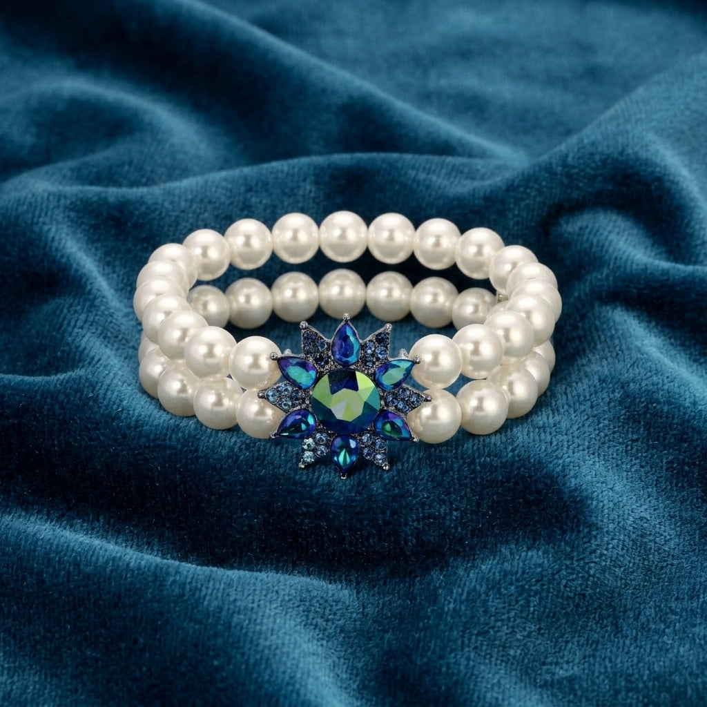 Pearl bracelet with a blue and green AB crystals on a blue fabric background