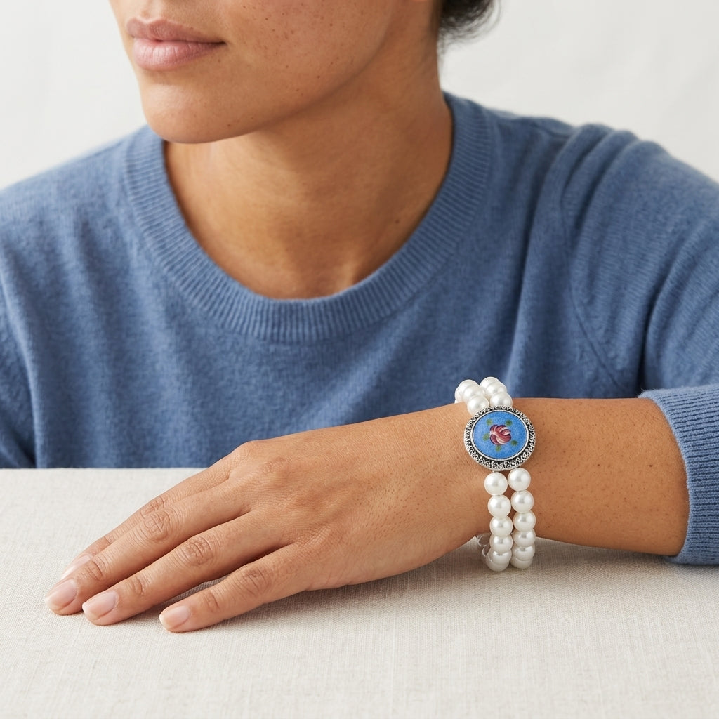 Person wearing a Silver Tone Blue & Pink Flower Decal Double Strand Pearl Bead Stretch Bracelet