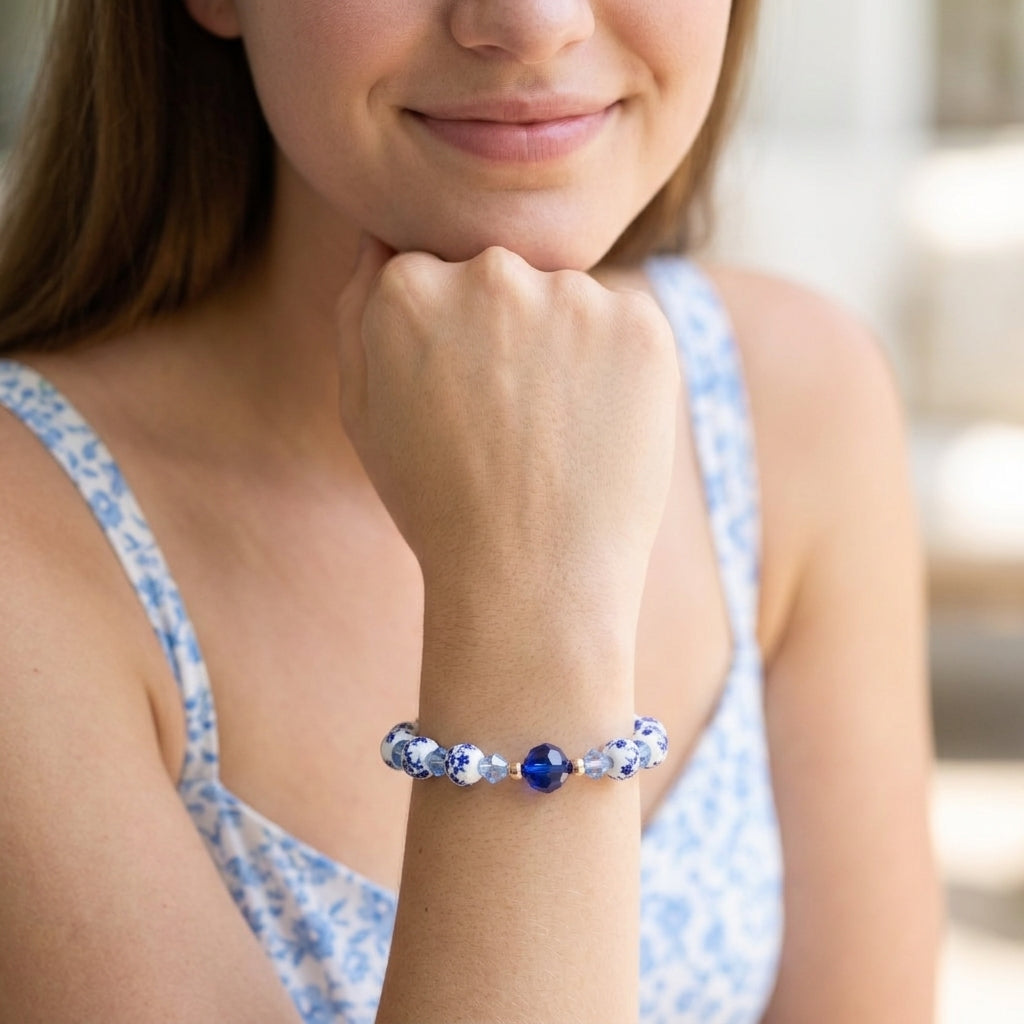 Woman wearing a blue beaded bracelet on her wrist with a blurred background