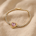 Dainty Stone Heart & Crystal Bracelet displayed on a textured beige fabric background.