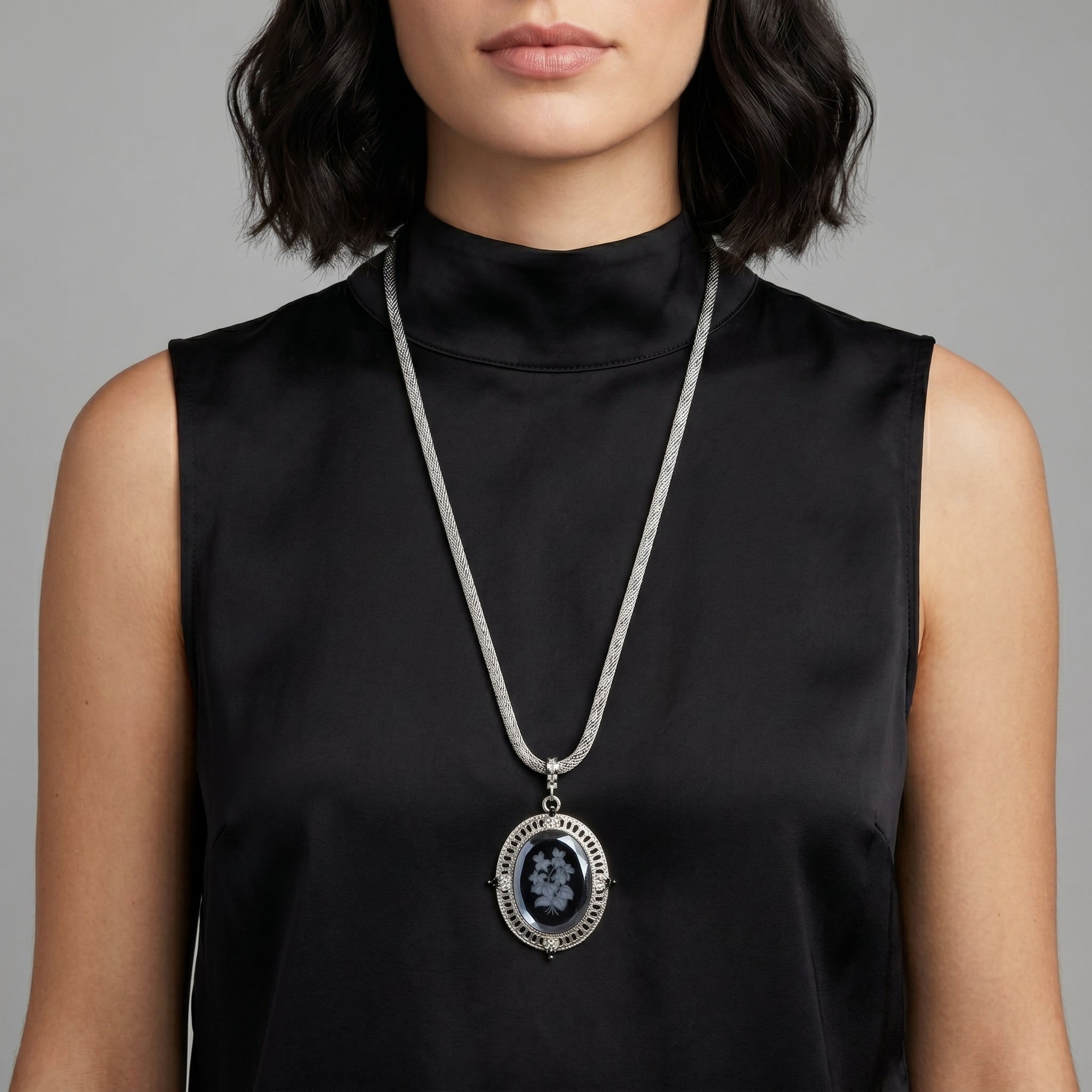 Woman wearing a black sleeveless top with a Black Intaglio Floral Stone Black & Clear Crystal Pendant Necklace
