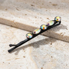 Crystal AB Bobby Pin on a textured beige stone surface