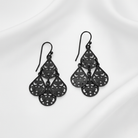 Black filigree earrings on a white background