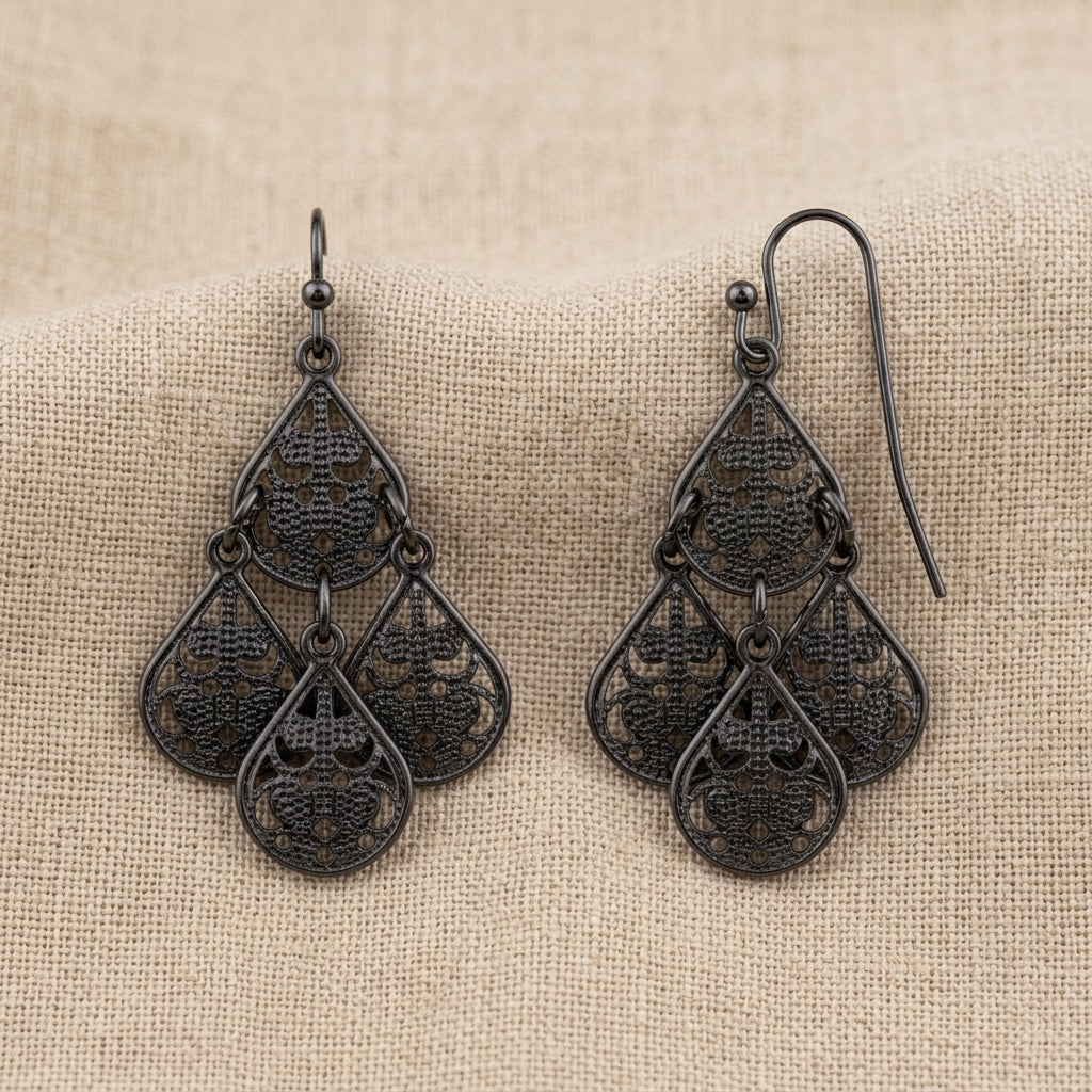 Filigree Teardrop Chandelier Earrings resting on beige linen