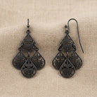 Filigree Teardrop Chandelier Earrings resting on beige linen
