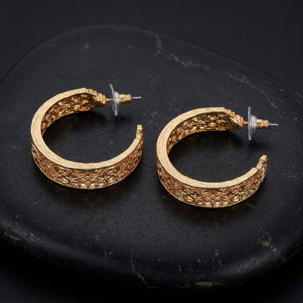 Gold Venice Treasure Filigree Hoop Earrings resting on black stone surface