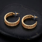 Gold Venice Treasure Filigree Hoop Earrings resting on black stone surface