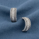 Crystal Hoop Earrings displayed on a textured blue fabric background.