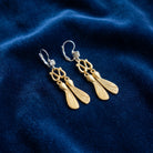 Antiquities Couture Two Tone Crystal Maple Seed Lever Back Earrings displayed on a dark blue velvet fabric background.