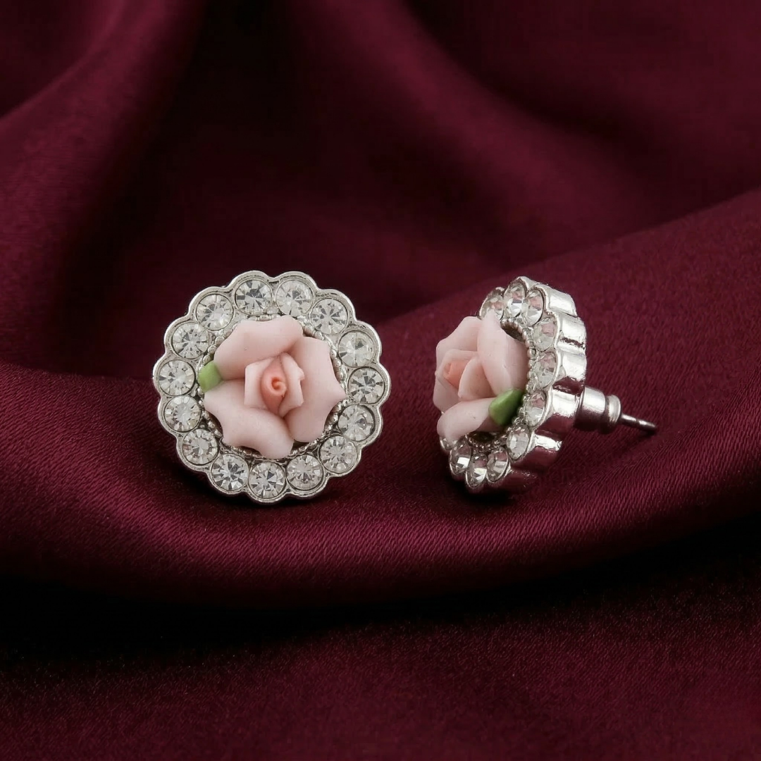 Pair of earrings with pink porcelain ose design on a red fabric background