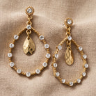 Golden Glitz Crystal Faceted Teardrop Earrings resting on beige fabric