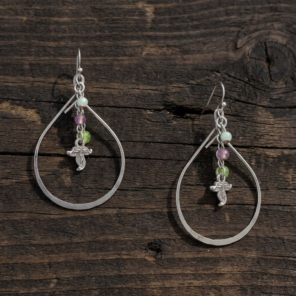 Winery Multi-Color Bead And Leaf Open Teardrop Earrings resting on dark picnic table wood