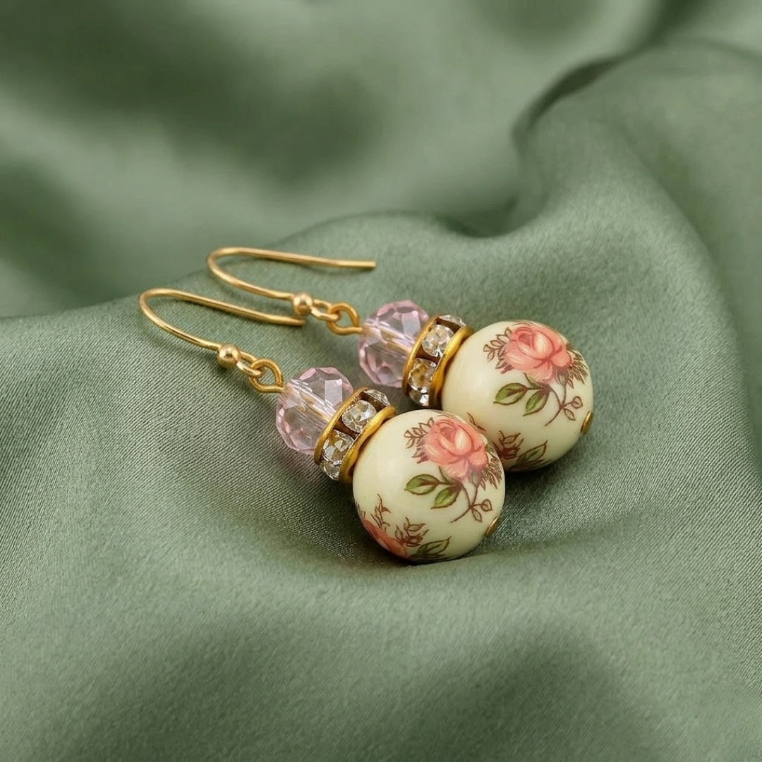 Pink Desert Rose Floral Decal Beaded Drop Earrings on light green fabric