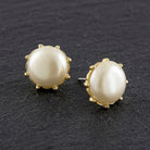 Round Faux Pearl Button Earrings displayed on a dark textured background.