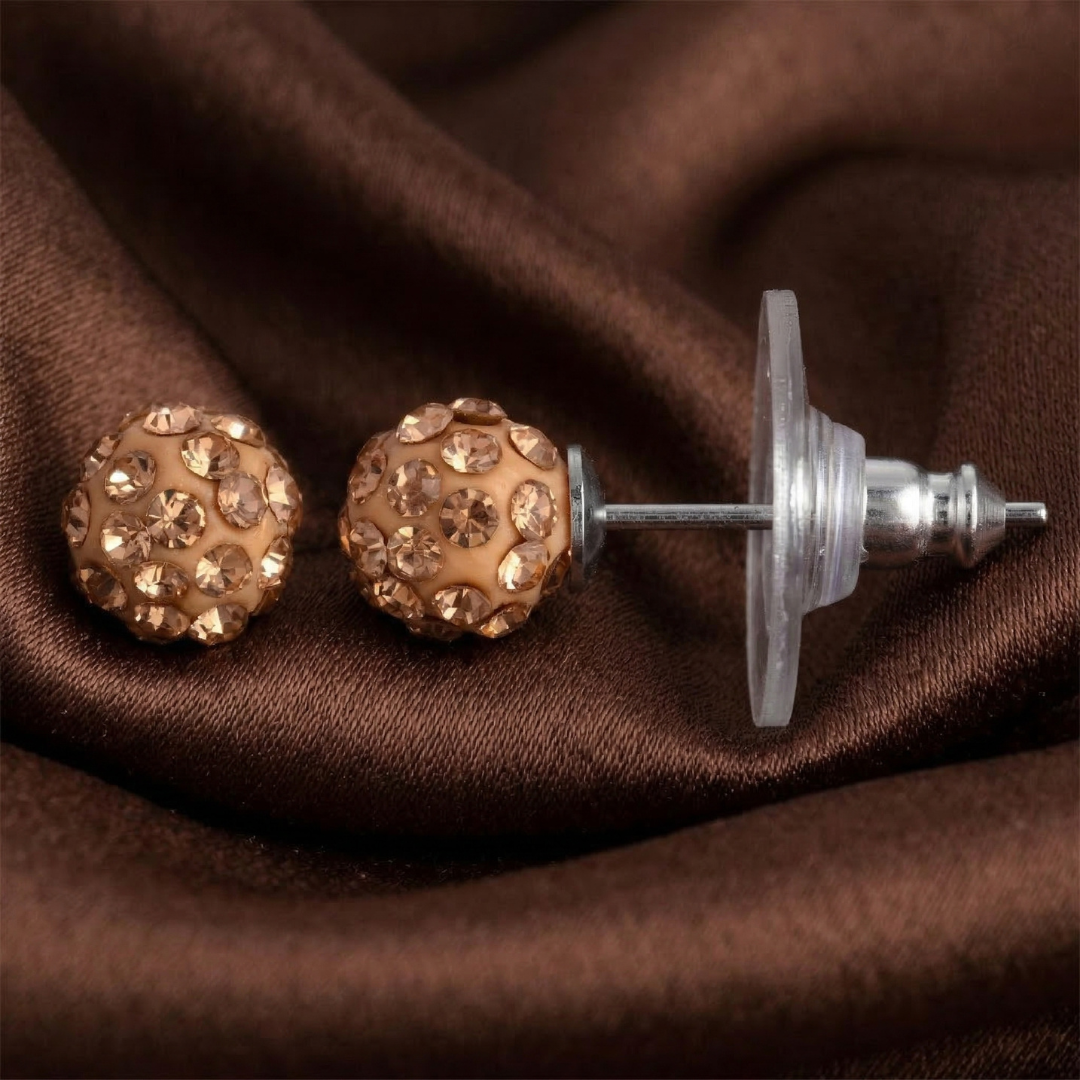 Brown crystal stud earrings on brown fabric