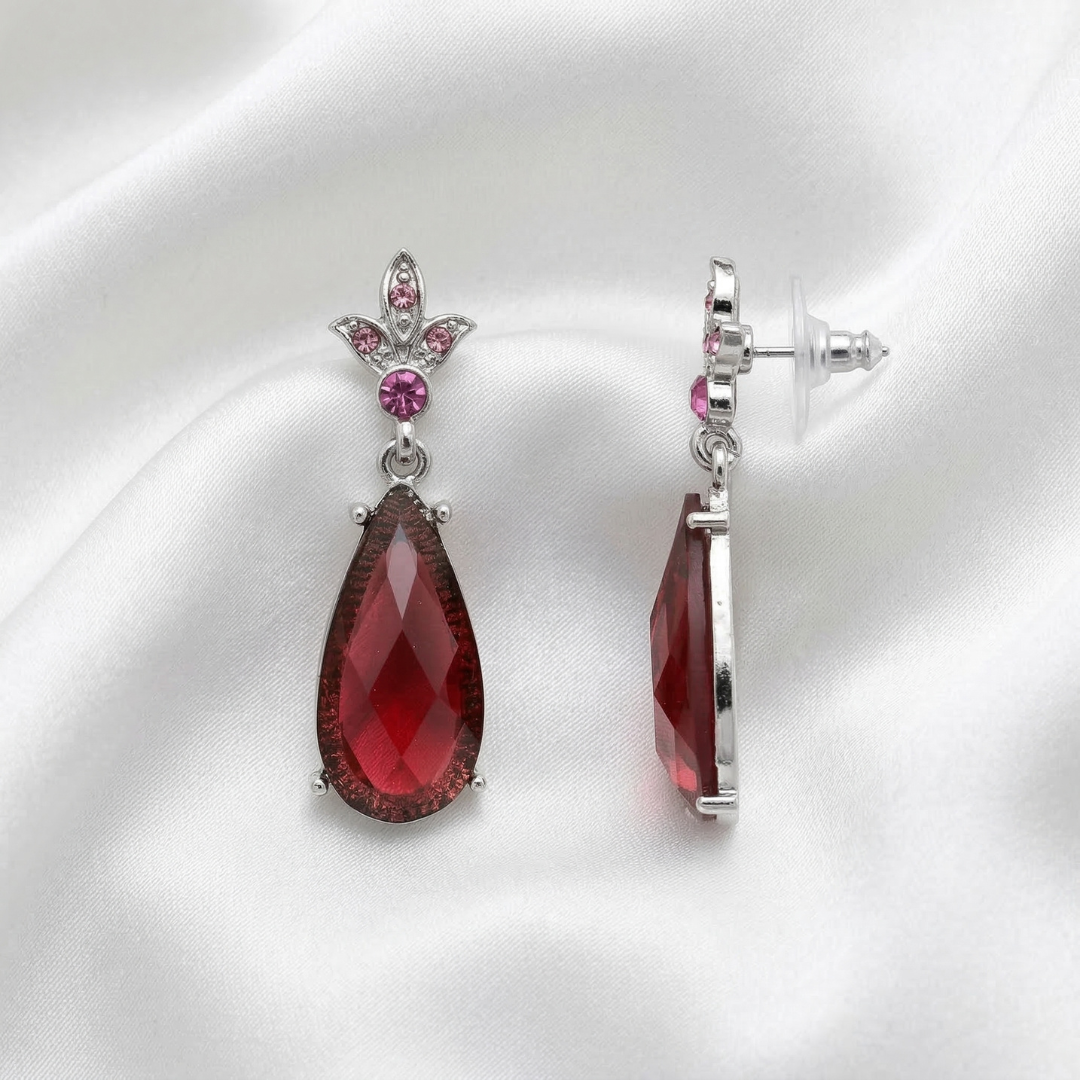 Amethyst teardrop earrings with silver and pink accents on a white satin background