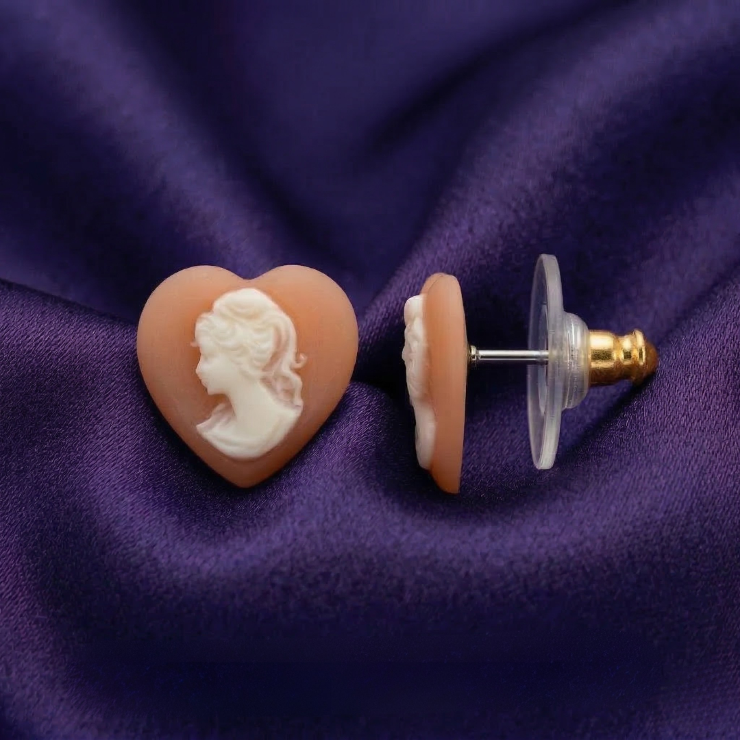 Heart-shaped cameo earring on a purple fabric background
