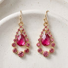 Fuchsia Multi Crystal Nested Teardrop Earrings resting on white pottery