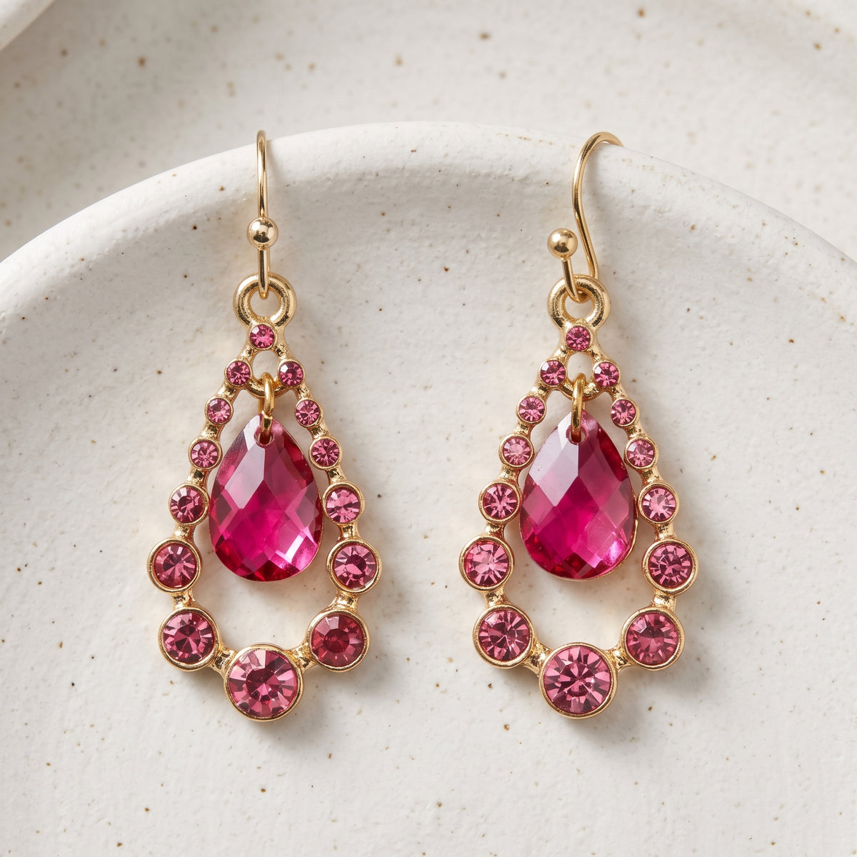 Fuchsia Multi Crystal Nested Teardrop Earrings resting on white pottery