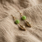Fireball Pave Crystal & Filigree Dangle Earrings resting on tan linen
