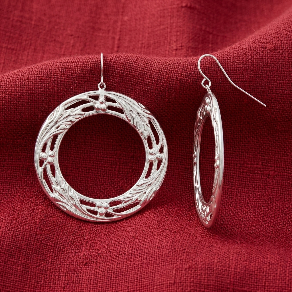 Polished Silver Vine Round Drop Earrings displayed on a textured red fabric background.