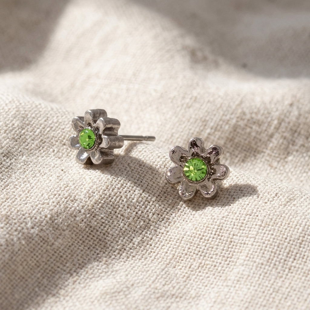 Light Green Crystal Tiny Flower Stud Earrings resting on light colored linen