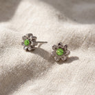 Light Green Crystal Tiny Flower Stud Earrings resting on light colored linen