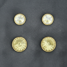 Citrine and crystal stud earrings on a gray textured background.