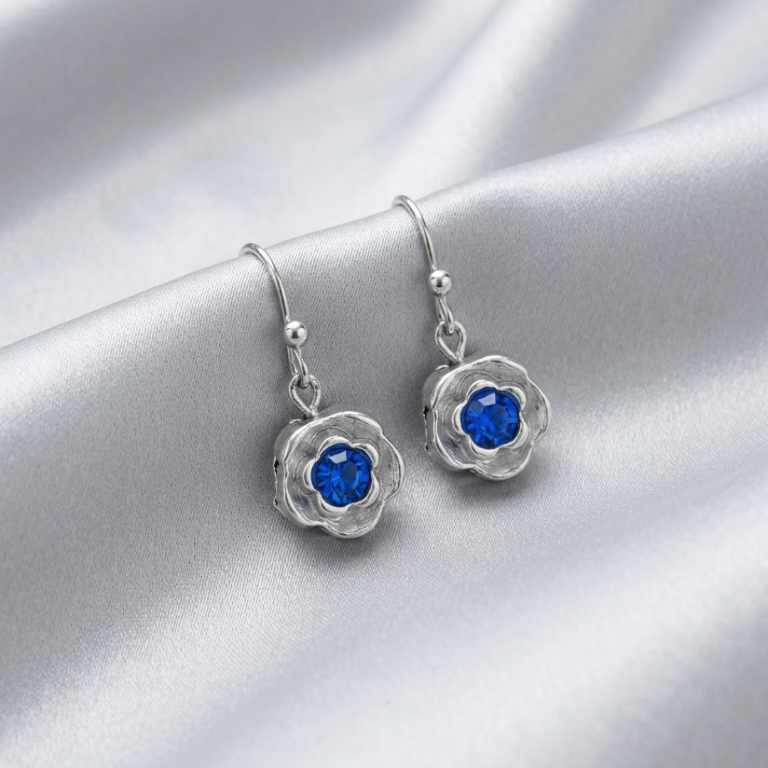 Silver earrings with blue crystals on a silver background