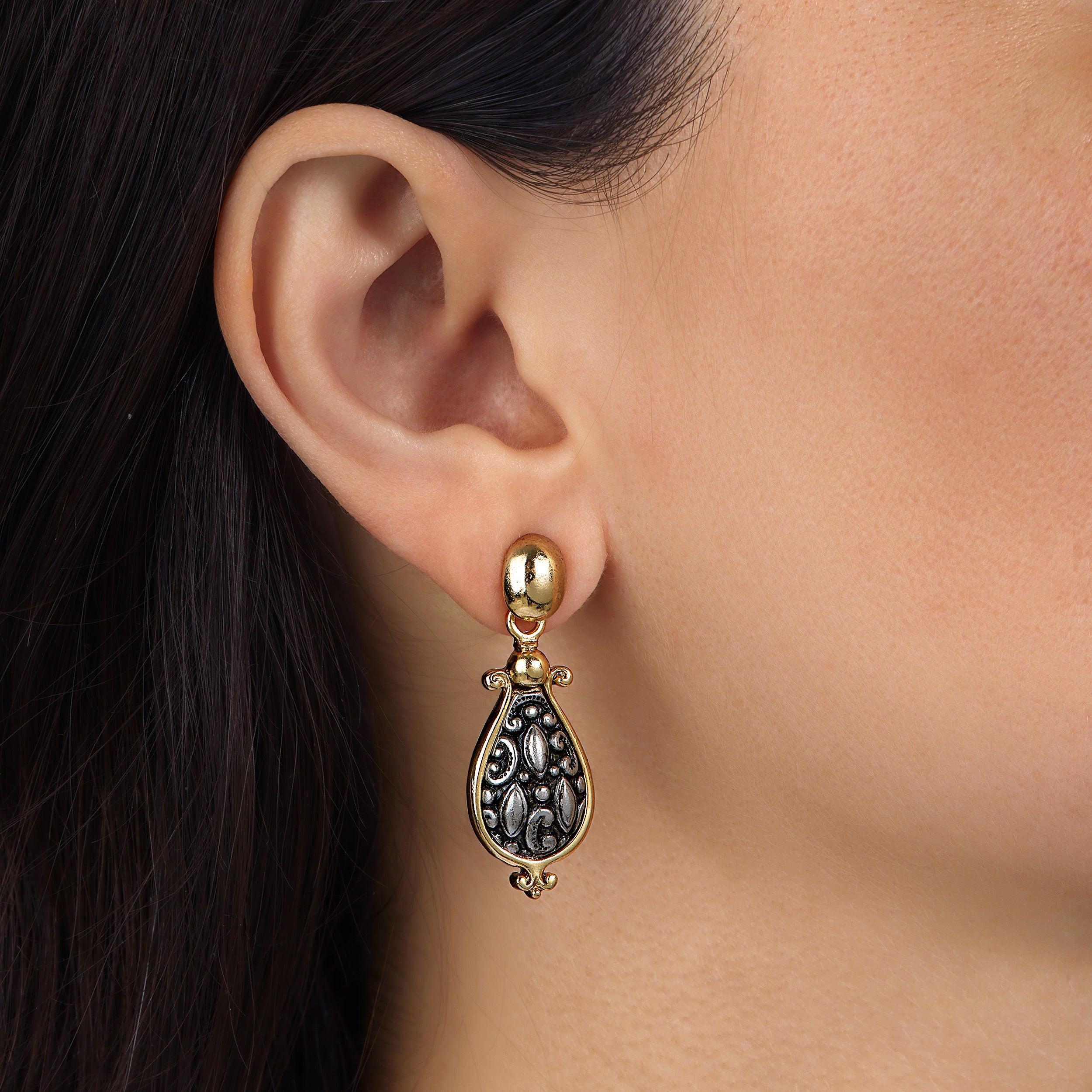 A close-up of a model's ear wearing an Antiquities Couture Antioch Teardrop Earrings
