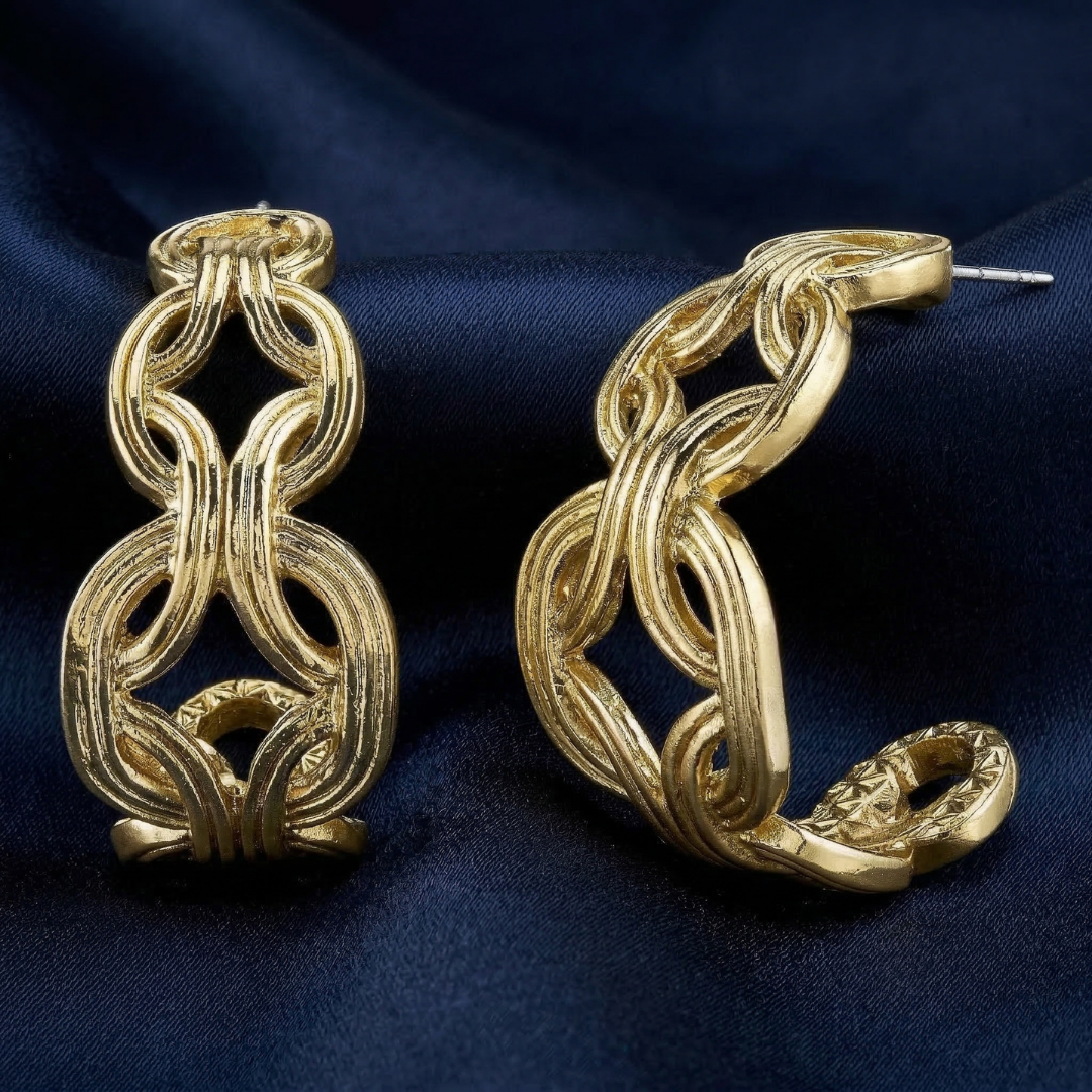 Gold tone hoop earrings on a dark blue fabric background